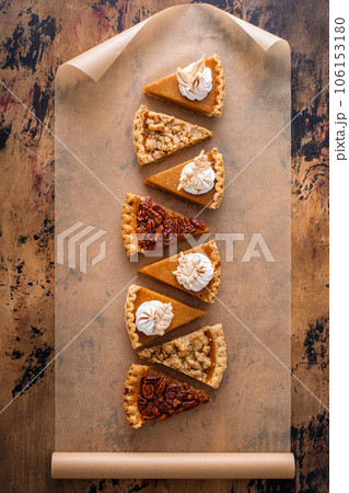 Traditional fall Thanksgiving pie slices, pumpkin and pecan pie Traditional fall Thanksgiving pie slices, pumpkin and pecan pie 106153180
