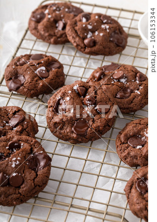 Double chocolate cookies with flaky salt on a cooling rack Double chocolate cookies with flaky salt on a cooling rack 106153344