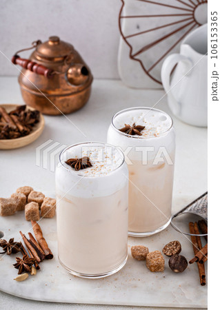 Iced chai latte with warm winter spices topped with milk foam Iced chai latte with warm winter spices topped with milk foam 106153365