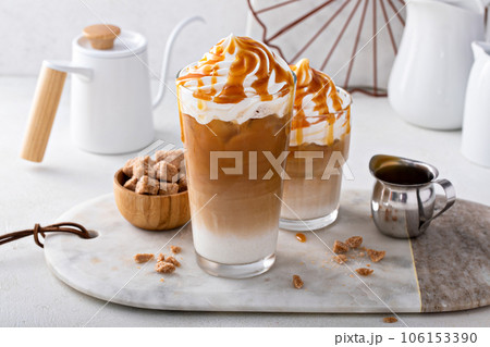 Iced caramel latte topped with whipped cream and caramel sauce Iced caramel latte topped with whipped cream and caramel sauce 106153390