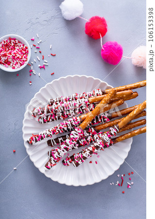 Valentines day treat, chocolate covered pretzel rods with sprinkles 106153398