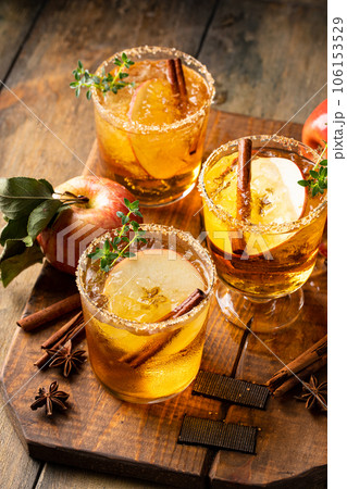 Apple cider margarita with brown sugar rim and cinnamon stick 106153529