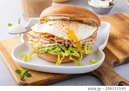 Turkey bagel breakfast sandwich with lettuce and fried egg 106153540