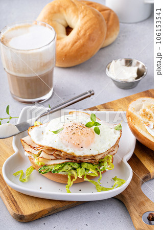 Turkey bagel breakfast sandwich with lettuce and fried egg 106153541