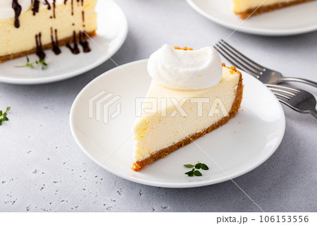 Slice of a traditional New York cheesecake with whipped cream Slice of a traditional New York cheesecake with whipped cream 106153556