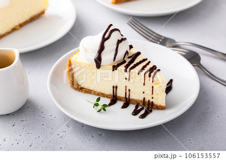 Slice of a traditional New York cheesecake with whipped cream Slice of a traditional New York cheesecake with whipped cream 106153557