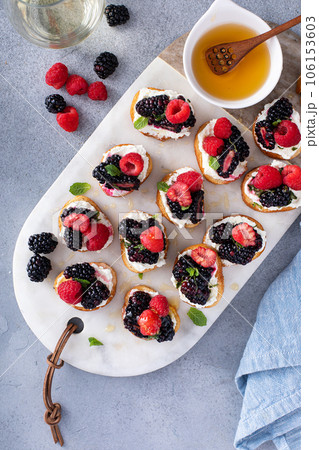 Berry and goat cheese bruschetta with mint and honey Berry and goat cheese bruschetta with mint and honey 106153603