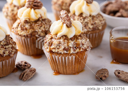 Candied pecan cupcakes with cream cheese frosting and caramel Candied pecan cupcakes with cream cheese frosting and caramel 106153756