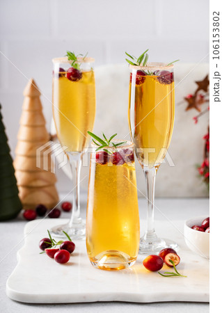 Festive Christmas mimosa with apple cider and cranberries 106153802