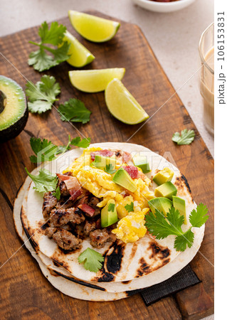 Breakfast tacos with sausage, eggs, bacon and avocado 106153831