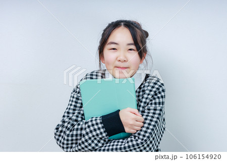 タブレットを抱えカメラ目線で微笑む女の子 タブレットを抱えカメラ目線で微笑む女の子 106154920