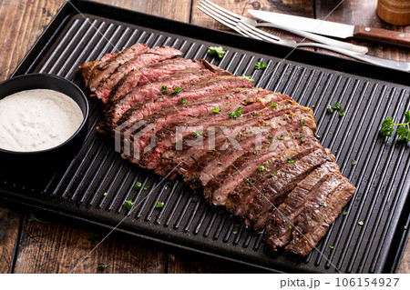 Grilled flank steak with horseradish sauce on a grill pan 106154927