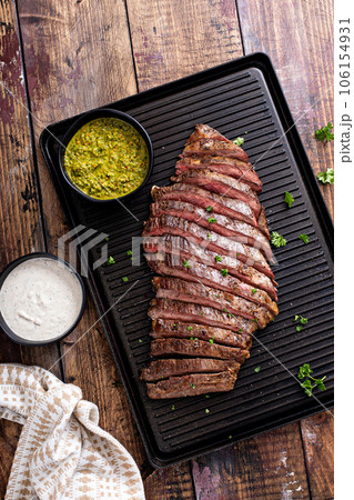 Grilled flank steak with chimichurri sauce on a grill pan Grilled flank steak with chimichurri sauce on a grill pan 106154931