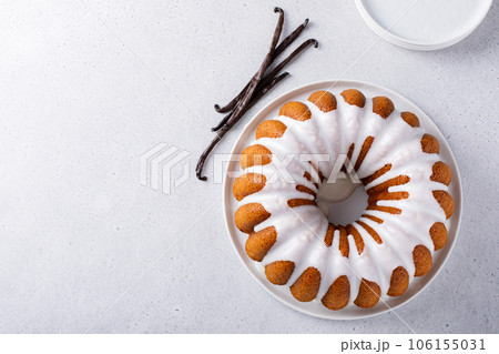 Vanilla bundt cake drizzled with powder sugar glaze 106155031