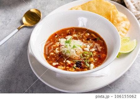 Chili served with crumbled cheese and tortilla 106155062
