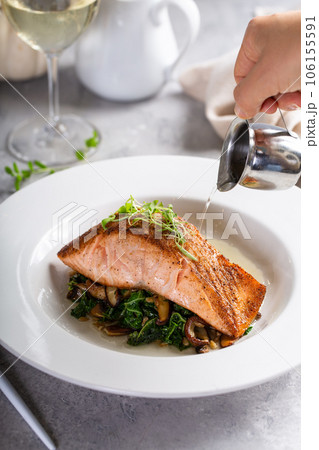 Roasted salmon served with greens, mushrooms and broth Roasted salmon served with greens, mushrooms and broth 106155591