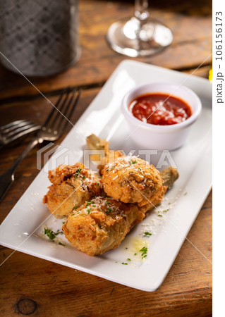 Fried lamb chops in parmesan batter with tomato sauce Fried lamb chops in parmesan batter with tomato sauce 106156173