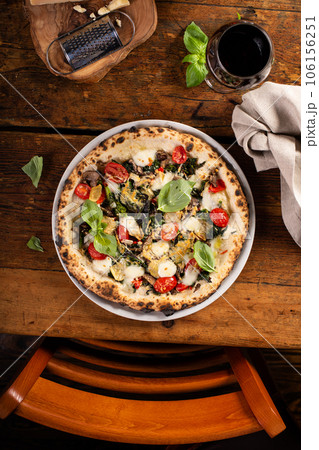 Freshly baked vegetarian Neapolitan pizza with mushrooms and artichokes 106156251