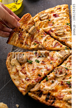 Bacon and sausage pizza on dark background 106156385
