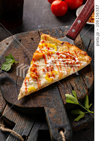 Chicken BBQ pizza with hot sauce, slice on a board Chicken BBQ pizza with hot sauce, slice on a board 106156387