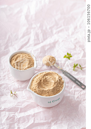 Maca powder in measuring cups and a spoon 106156700