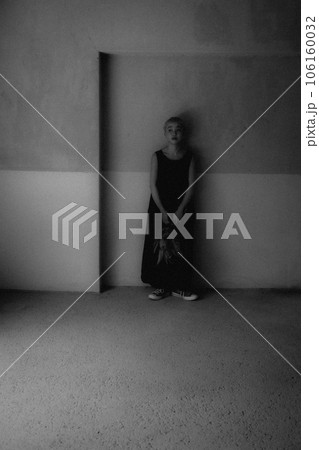 屋内に佇む若い女性のモノクロ写真 106160032