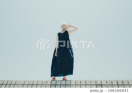 空バックに佇む女性 106160841