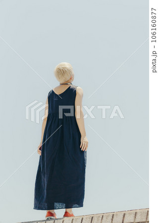 空バックに佇む女性 106160877