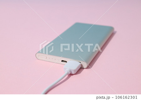 Powerbank and cord on pink background, close up Powerbank and cord on pink background, close up 106162301