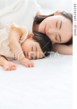 リビングで昼寝をする赤ちゃんと若いお母さん 106163289