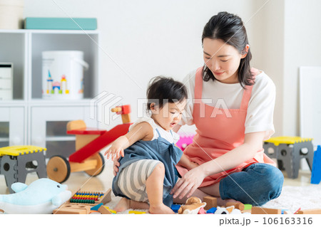保育園で赤ちゃんと遊ぶ若い保育士 106163316