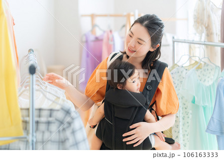 ショッピングモールでショッピングをする赤ちゃんを連れた若いお母さん ショッピングモールでショッピングをする赤ちゃんを連れた若いお母さん 106163333