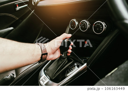 Driver hand holding gear lever of automatic transmission and hand moves the gear lever in the car 106163449