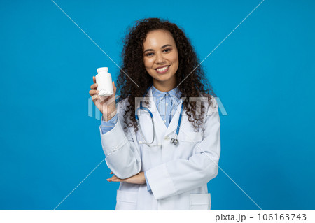 An attractive young girl in a white doctor's uniform on a blue background An attractive young girl in a white doctor's uniform on a blue background 106163743