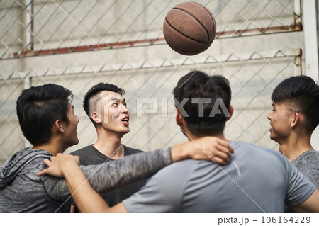 young asian adult men having fun playing with basketball outdoors 106164229