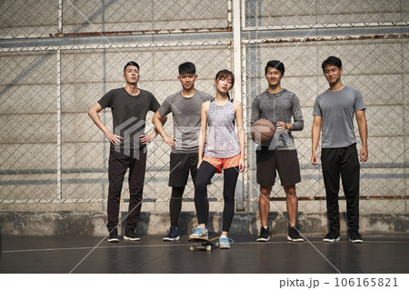 hipster young asian woman posing outdoors with skateboard and four male friends 106165821