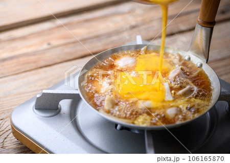 親子丼 和食の定番!アツアツの親子丼を作る(とき卵をかける)(古板白背景) 親子丼 和食の定番!アツアツの親子丼を作る(とき卵をかける)(古板白背景) 106165870