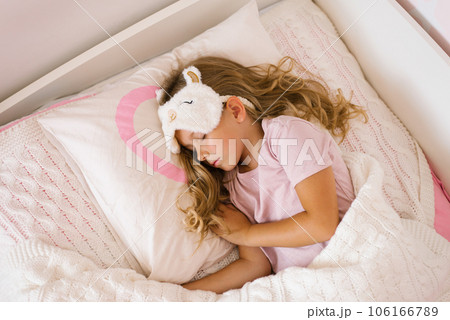 Little girl is sleeping in her bed on a pillow. Sweet peaceful sleep of a child. Little girl is sleeping in her bed on a pillow. Sweet peaceful sleep of a child. 106166789