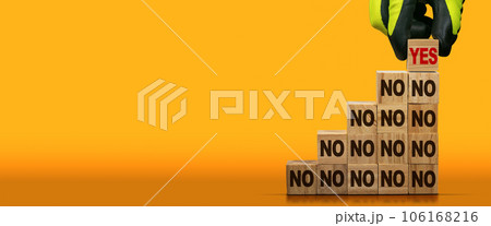 Stack of Wooden Blocks with Text Yes or No on Orange Background 106168216