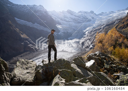 Hiker man with in the alpine mountains. Mountain with glacier and tourist 106168484