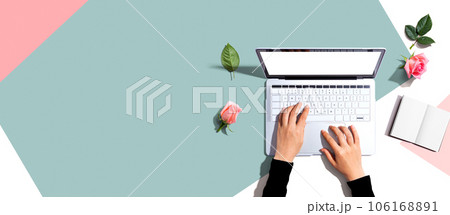 Woman using her laptop with pink roses 106168891