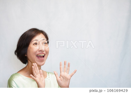 上を向いて両手を開いて驚く中年女性 拍手する中年女性 上を向いて両手を開いて驚く中年女性 拍手する中年女性 106169429