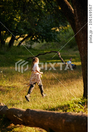 Little active child, girl in casual clothes running, playing in meadow in forest on warm sunny day Little active child, girl in casual clothes running, playing in meadow in forest on warm sunny day 106169567