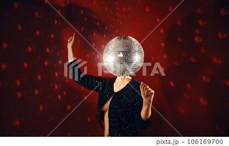 Woman in sequin dress with disco ball instead of head dancing at a party 106169700