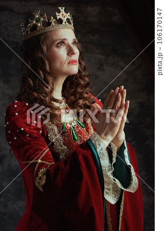 medieval queen in red dress with crown praying medieval queen in red dress with crown praying 106170147