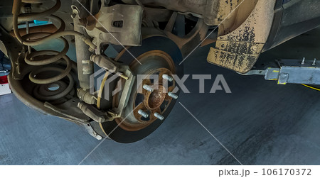Car disc brake system. Car suspension in process of new tire replacement at garage workshop. Car disc brake mechanic check and repair. Disk break rotor. Car in change tire process at service station. Car disc brake system. Car suspension in process of new tire replacement at garage workshop. Car disc brake mechanic check and repair. Disk break rotor. Car in change tire process at service station. 106170372