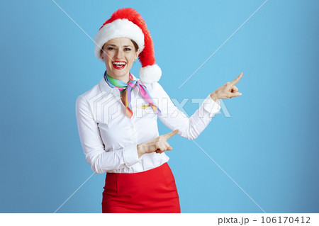 happy modern air hostess woman on blue pointing at something 106170412