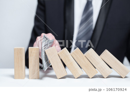 Wooden blocks under money dollars protection, domino, insurance safety property concept Wooden blocks under money dollars protection, domino, insurance safety property concept 106170924
