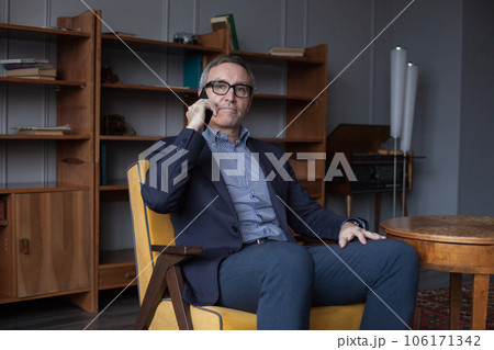 Nervous serious businessman in blue suit and glasses talking on his mobile phone Nervous serious businessman in blue suit and glasses talking on his mobile phone 106171342