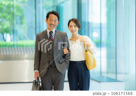 ミドルカップルを案内する受付の女性 106171568